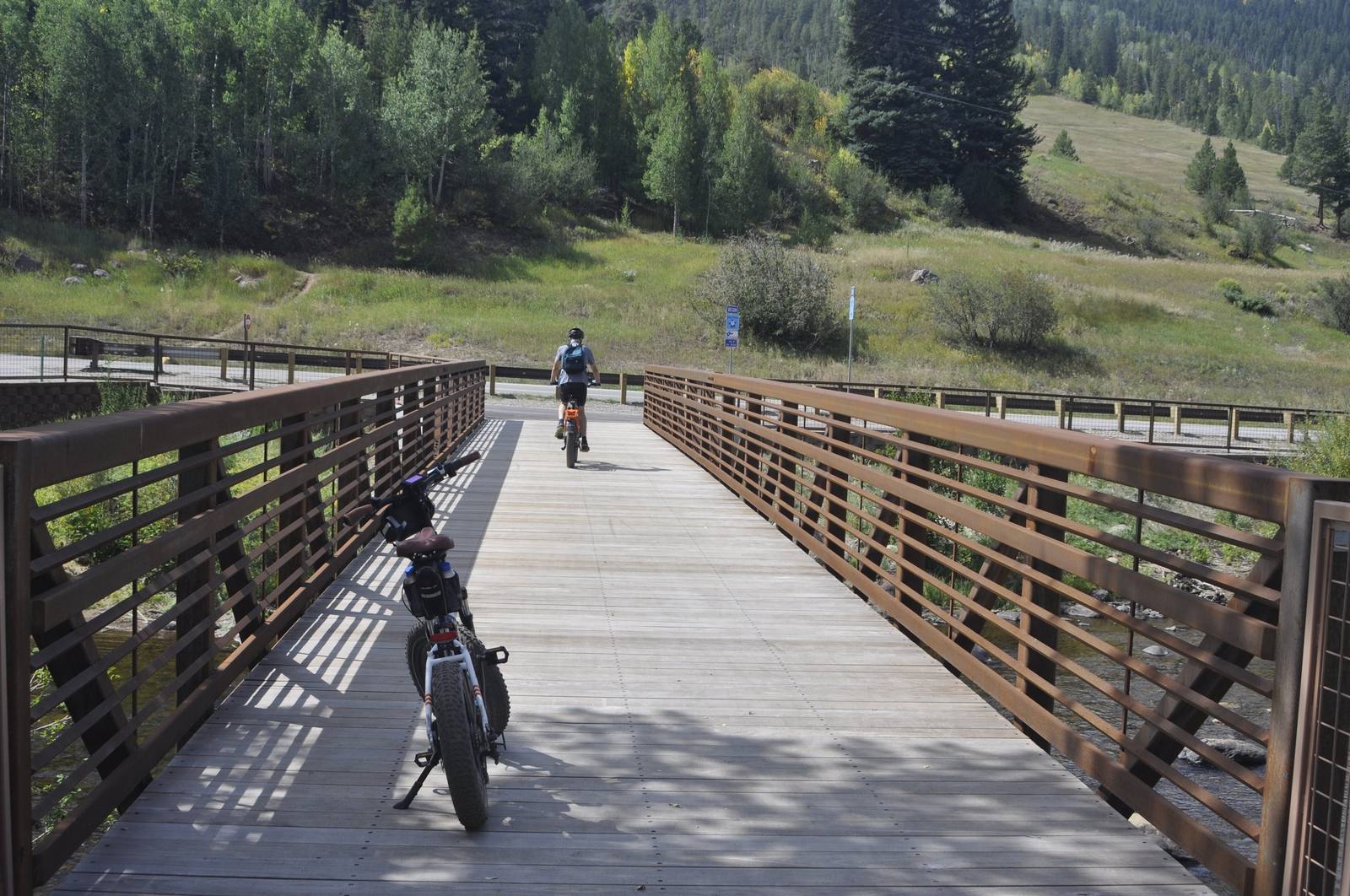 A cyclist crosses a bridge on the Eagle Valley Trail.
