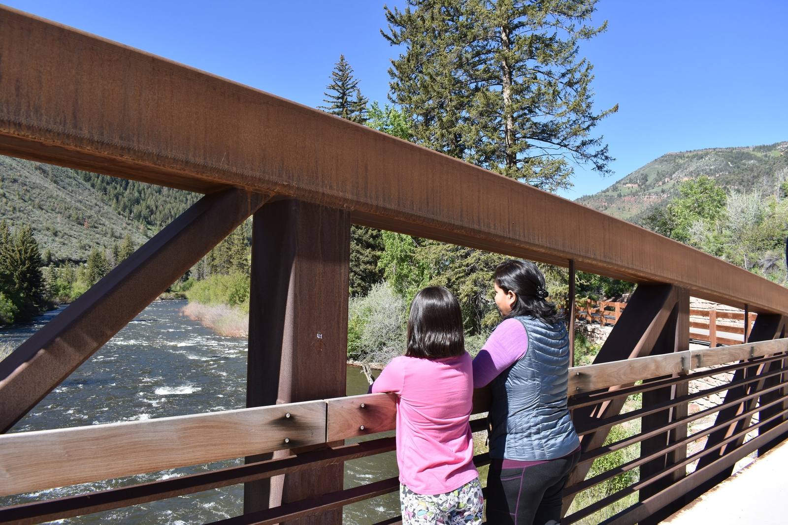 Two trail users pause on the Horn Ranch Bridge over the Eagle River.