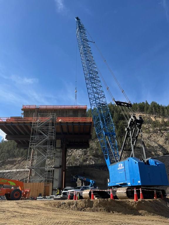 A crane beside a Floyd Hill bridge pier under construction, in a CDOT photograph dated March 26, 2026. The westbound closures on Oct. 19 and 20 let crews grout the tendons on the segmental bridge above westbound I-70 at US 6.