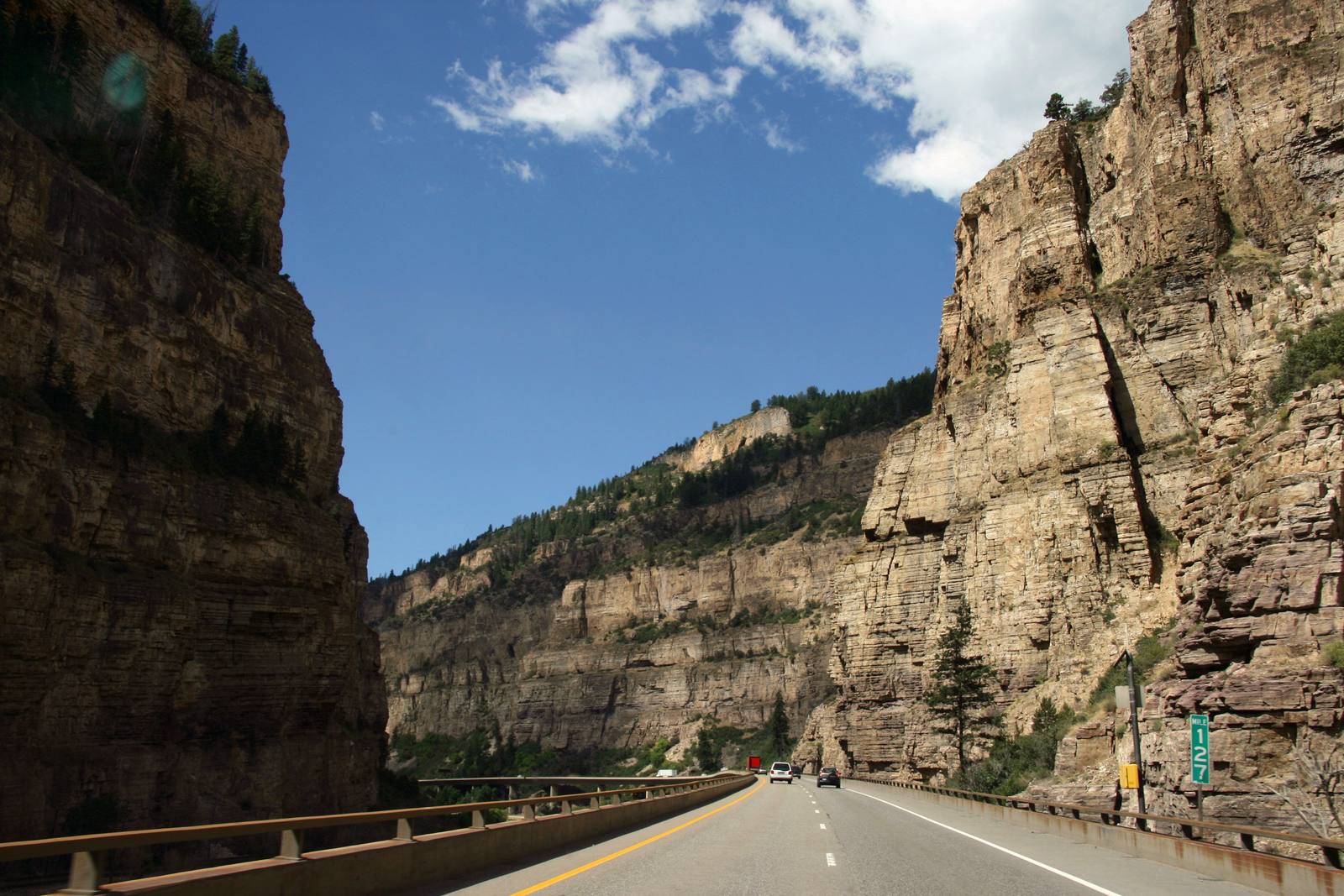 Westbound Interstate 70 through Glenwood Canyon, near Mile 127. Westbound drivers face single-lane closures and holds of up to 10 minutes before the Hanging Lake Tunnel during work hours.